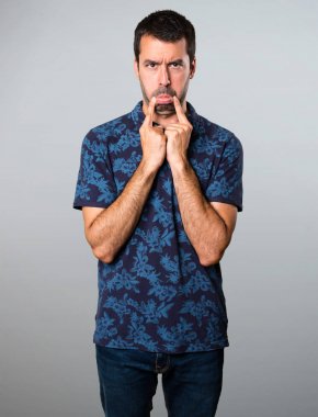 Gri arka plan üzerinde üzgün esmer adam