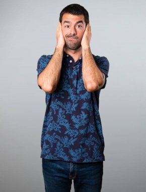 Esmer adam gri arka plan üzerinde kulakları kapsayan