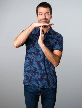 Esmer adam yapma zaman aşımı jest gri arka plan üzerinde