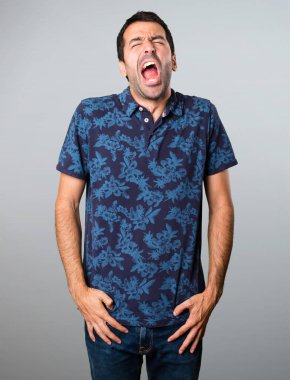 Esmer adam gri arka plan üzerinde esneme