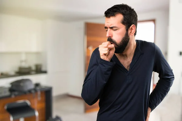 Bonito homem com barba tosse muito dentro de casa — Fotografia de Stock