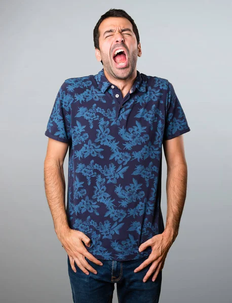 Esmer adam gri arka plan üzerinde esneme