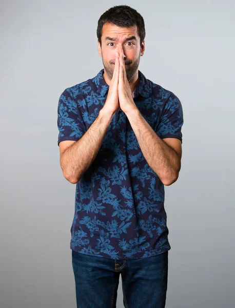 Esmer adam gri arka plan üzerinde yalvaran