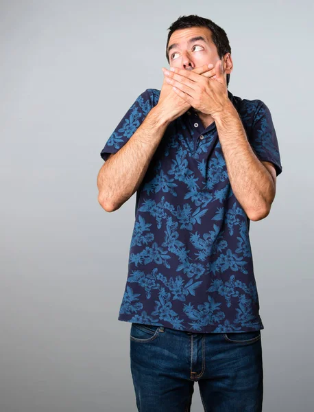 Esmer adam yapma sürpriz jest gri arka plan üzerinde