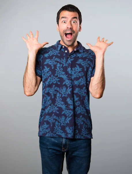 Esmer adam yapma sürpriz jest gri arka plan üzerinde