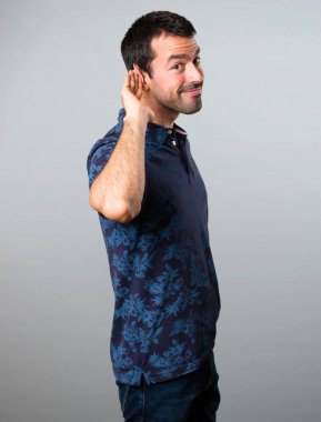 Esmer adam gri arka plan üzerine bir şey dinleme