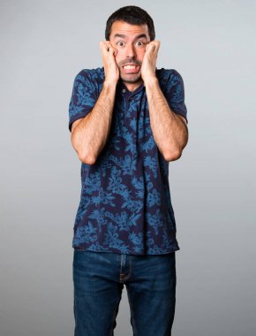 Esmer adam gri arka plan üzerinde korkuttu