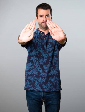 Esmer adam gri arka plan üzerinde kırmızı yapma