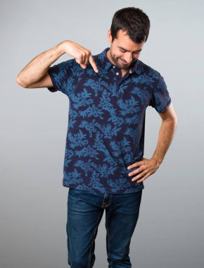 Esmer adam gri arka plan üzerinde aşağı dönük