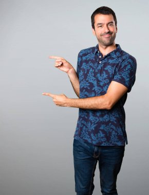 Esmer adam lateral gri arka plan üzerine işaret