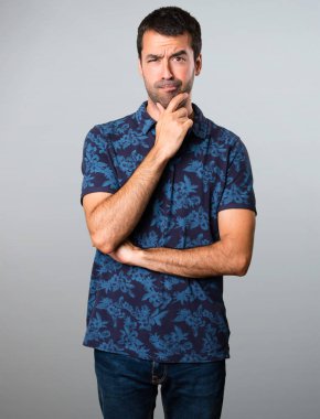 Esmer adam gri arka plan üzerinde düşünme