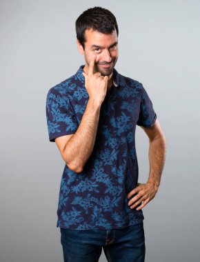 Esmer adam bir şey gri arka plan üzerinde gösterilen