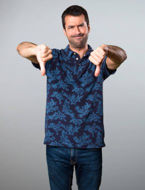 Esmer adam kötü sinyal gri arka plan üzerinde yapma