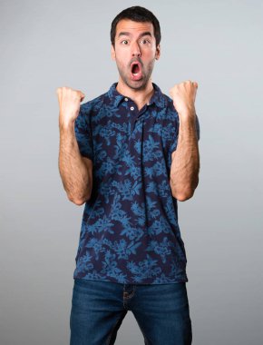 Gri arka plan üzerinde şanslı esmer adam