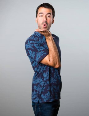 Esmer adam gri arka plan üzerinde bir öpücük gönderme