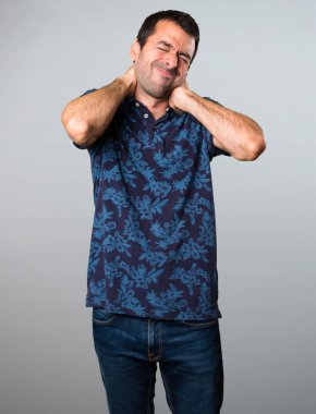 Esmer adam gri arka plan üzerinde boyun ağrısı ile