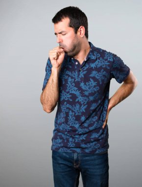 Esmer adam çok gri arka plan üzerinde öksürük