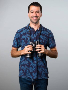 Esmer adam gri arka plan üzerinde dürbün ile