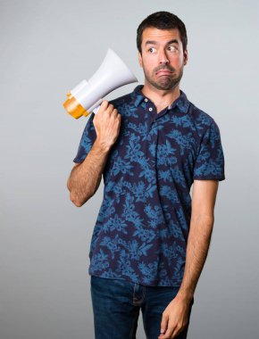 Esmer adam bir megafon gri arka plan üzerinde tutan