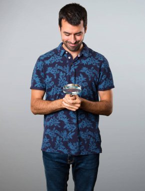 Esmer adam gri arka plan üzerinde büyüteç ile