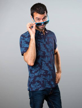 Gri arka plan üzerinde gözlüklü esmer adam