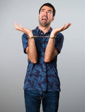 Esmer adam gri arka plan üzerinde kelepçe ile