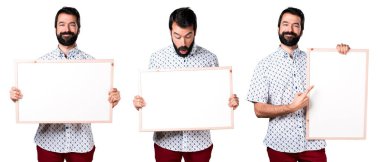 Boş bir afiş tutarak sakallı yakışıklı esmer adam
