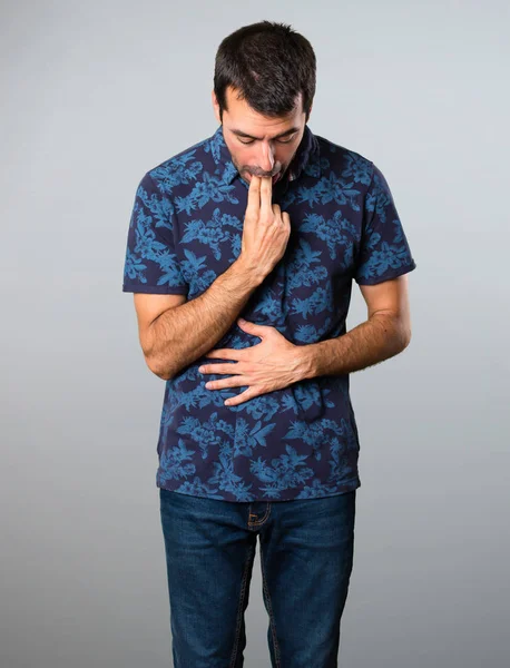 Esmer adam gri arka plan üzerine kusma jest yapma