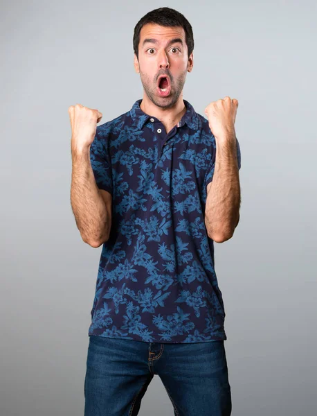 Gri arka plan üzerinde şanslı esmer adam