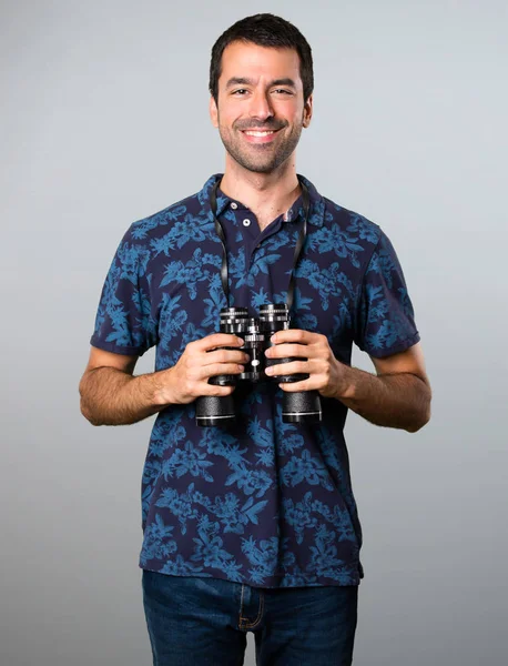 Esmer adam gri arka plan üzerinde dürbün ile