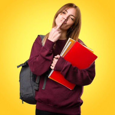 Öğrenci kadın yapma boynuz jest renkli arka plan üzerinde