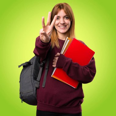 Öğrenci kadın üç renkli arka plan üzerinde sayma