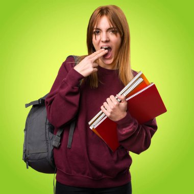 Renkli arka plan üzerinde kusma jest yaparak öğrenci kadın