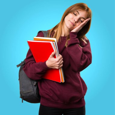 Öğrenci kadın yapma uyku jest renkli arka plan üzerinde