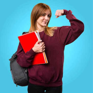 Öğrenci kadın renkli arka plan üzerinde güçlü bir jest yapma