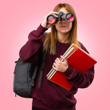 Renkli arka plan üzerinde dürbün ile öğrenci kadın