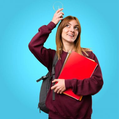 Bir ampul renkli arka plan üzerinde tutan öğrenci kadın