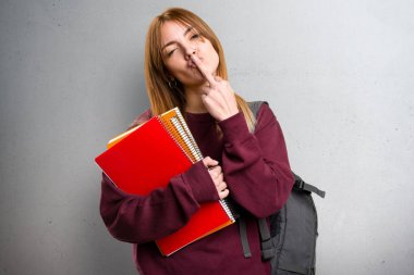 Öğrenci kadın yapma boynuz jest gri arka plan üzerinde