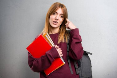 Öğrenci kadın deli jest gri arka plan üzerinde yapma