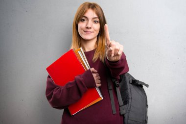 Öğrenci kadın bir gri arka plan üzerinde sayma