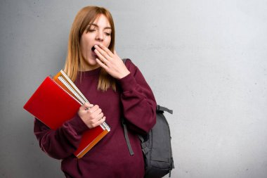 Gri arka plan üzerinde esneme öğrenci kadın