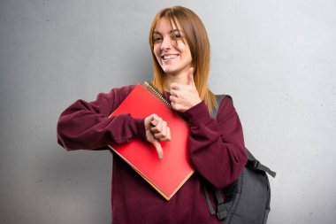 İyi-kötü işareti gri arka plan üzerinde yapma öğrenci kadın