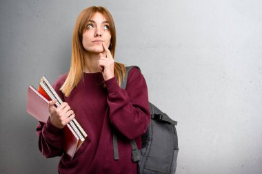 Gri arka plan üzerinde düşünme öğrenci kadın