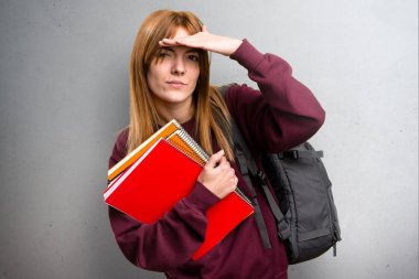 Bir şey gri arka plan üzerinde gösterilen öğrenci kadın
