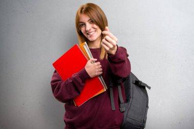 Öğrenci kadın yapım para jest gri arka plan üzerinde