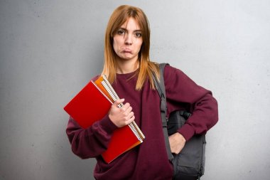 Gri arka plan üzerinde üzgün öğrenci kadın