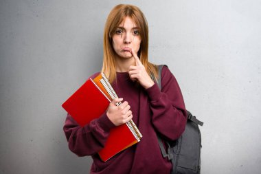 Gri arka plan üzerinde üzgün öğrenci kadın