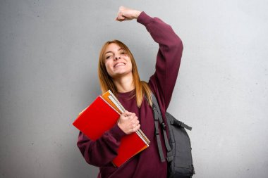 Şanslı öğrenci kadın gri arka plan üzerinde