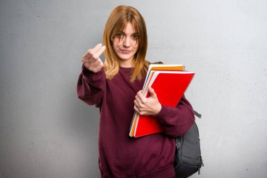 Öğrenci kadının gri arka plan üzerinde önümüzdeki jest yapması