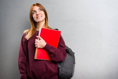 Gri arka plan üzerinde ararken öğrenci kadın